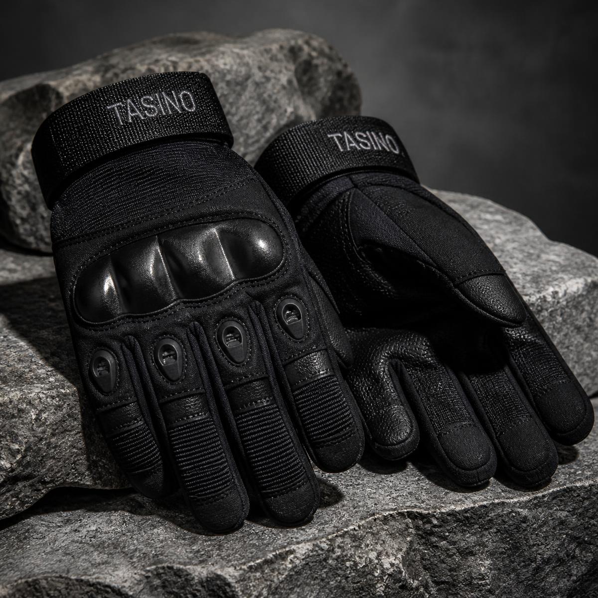 Pair of black TASINO tactical gloves with hard knuckles resting on grey stone